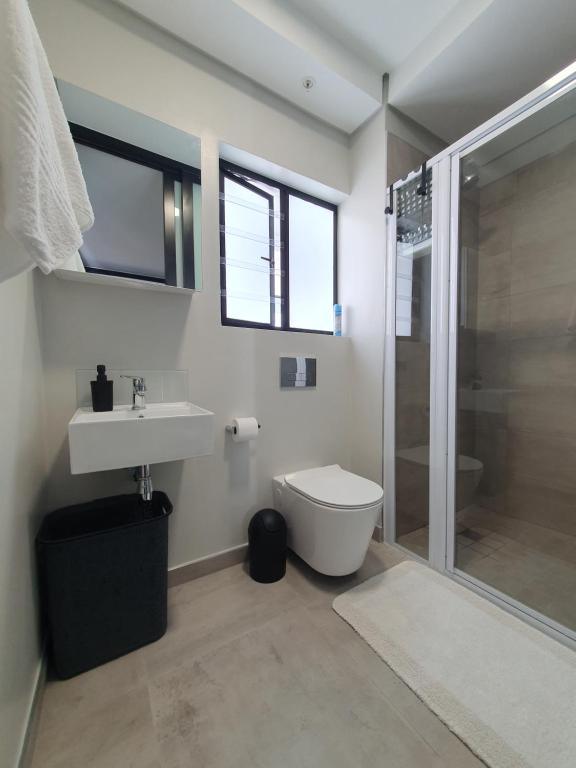 a bathroom with a toilet and a sink and a shower at The Paramount and The Supreme at Bellamare in Summerstrand