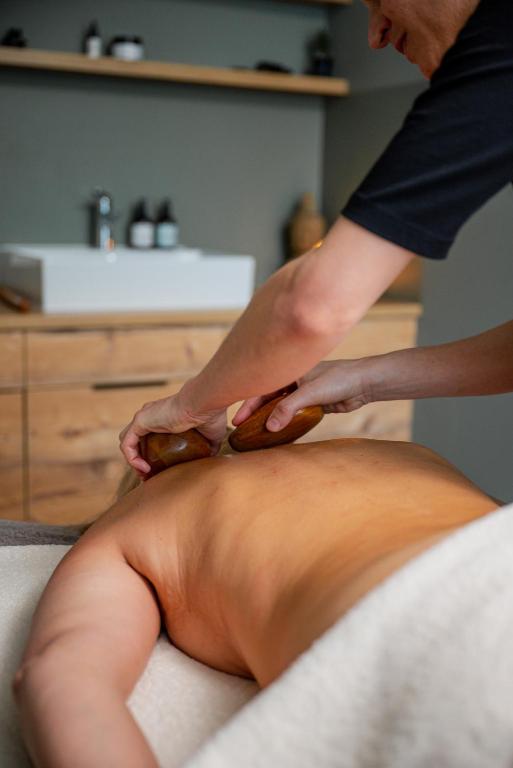 a man getting a massage on a mans back at Alpenhotel Montafon & SPA in Schruns