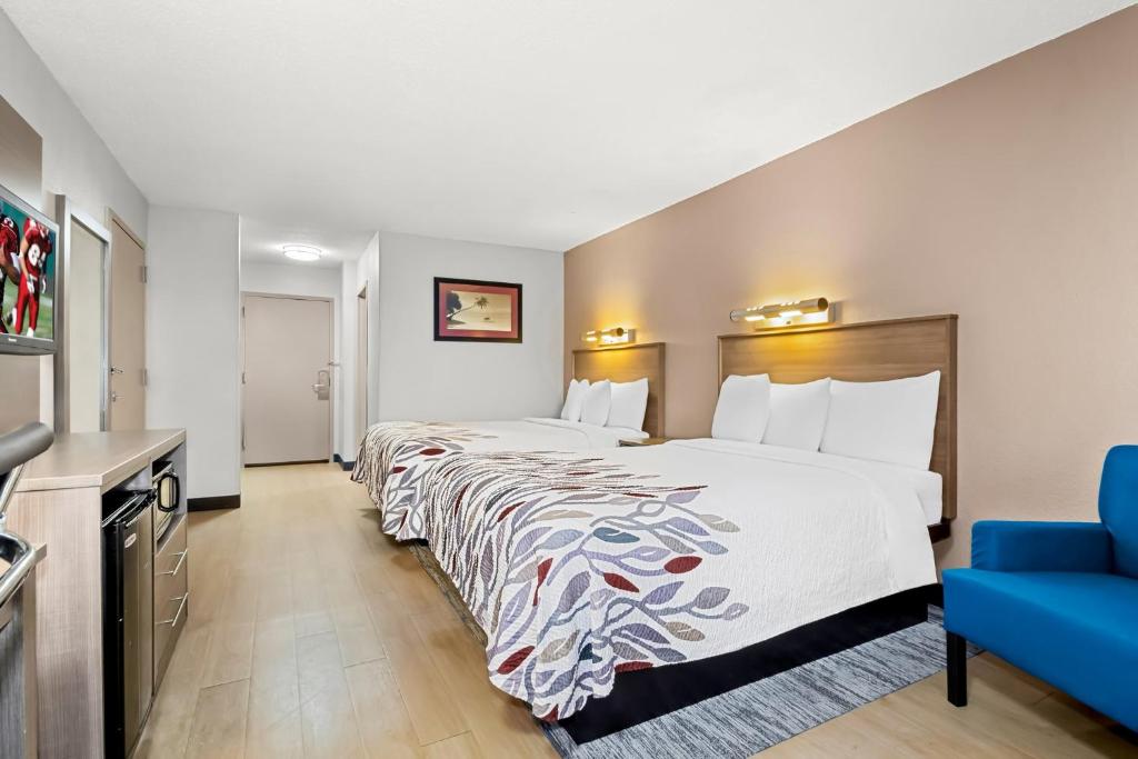 a hotel room with a bed and a blue couch at Red Roof Inn Myrtle Beach Hotel - Market Commons in Myrtle Beach
