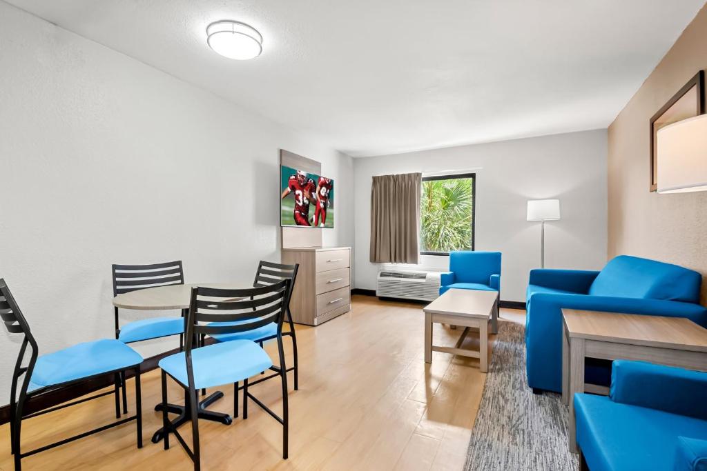 a living room with blue chairs and a table at Red Roof Inn Myrtle Beach Hotel - Market Commons in Myrtle Beach