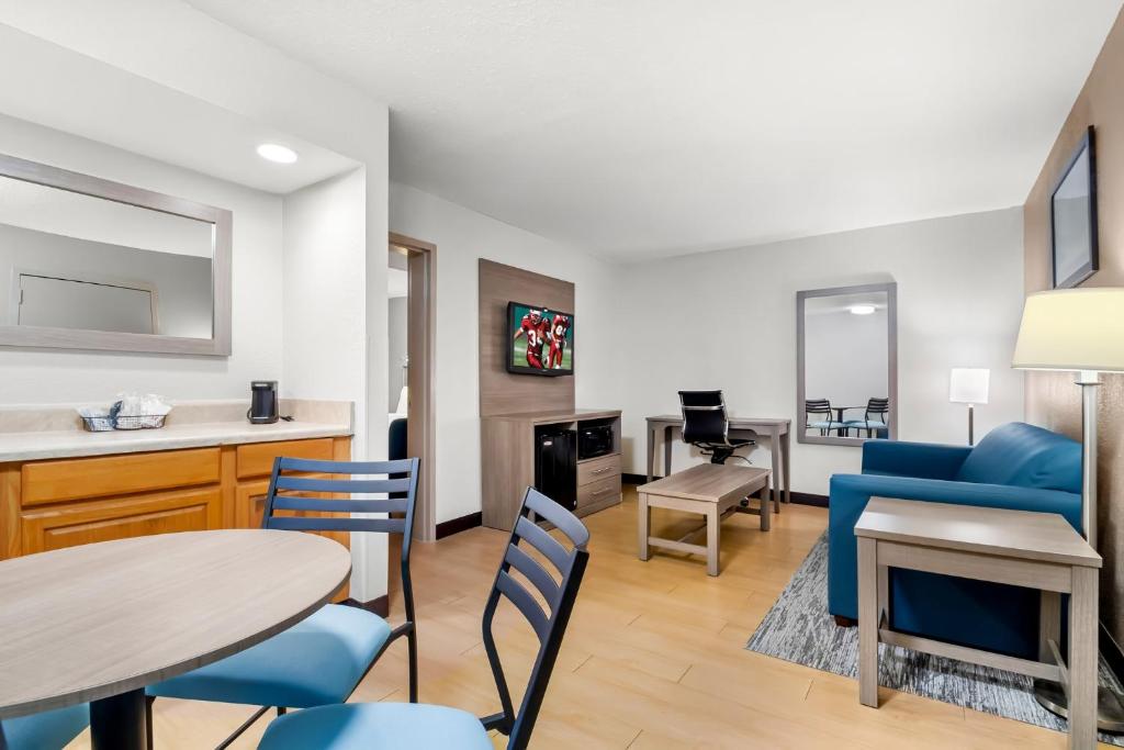 a living room with a blue couch and a table and chairs at Red Roof Inn Myrtle Beach Hotel - Market Commons in Myrtle Beach