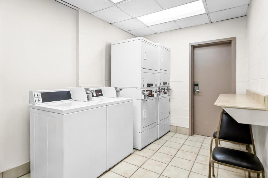 a laundry room with white appliances and a chair at Red Roof Inn Myrtle Beach Hotel - Market Commons in Myrtle Beach