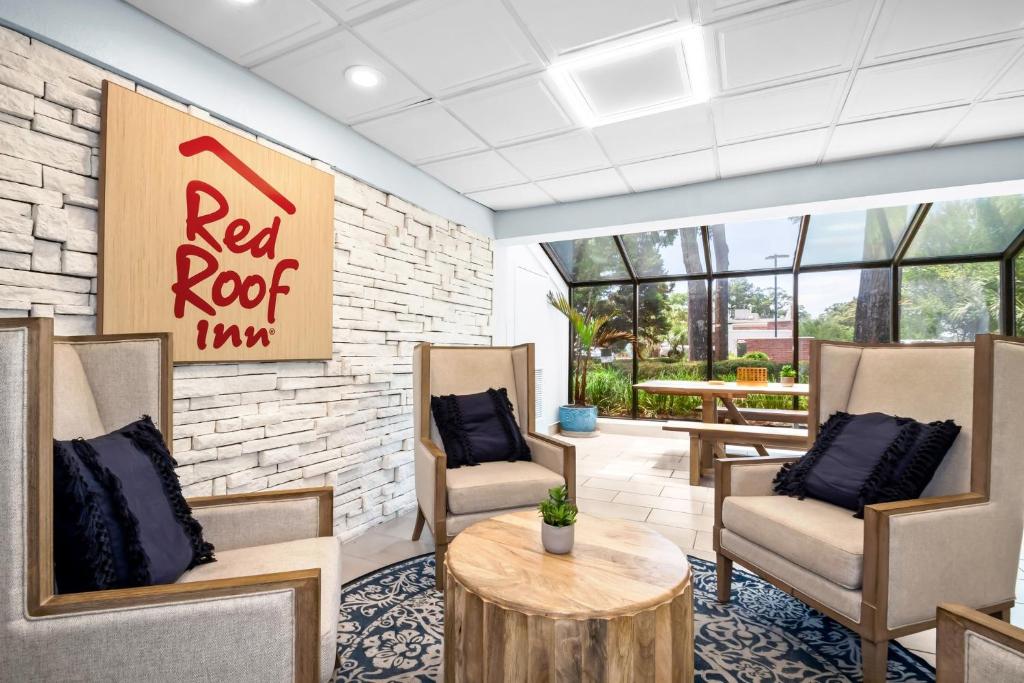 a lobby with chairs and a table and a red roof inn sign at Red Roof Inn Myrtle Beach Hotel - Market Commons in Myrtle Beach