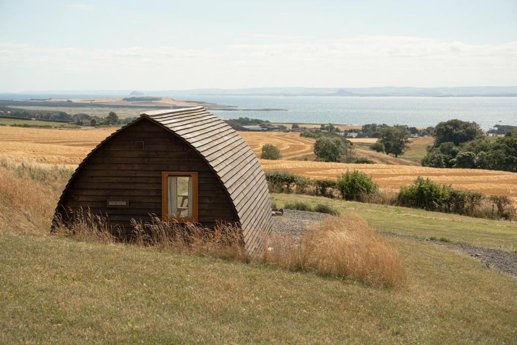 a small wooden hut on a hill in a field at Largo Law by Wigwam Holidays in Kirkton of Largo