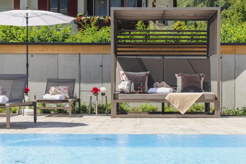 a couple of chairs with pillows next to a pool at Alpenhotel Montafon & SPA in Schruns