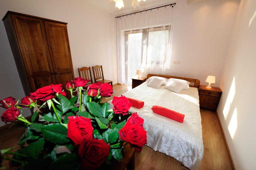 a bedroom with a bed with red roses on it at Willa Julia in Krakow