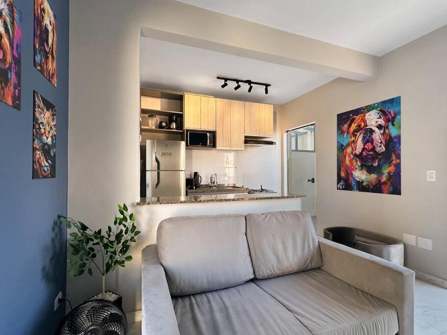ein Wohnzimmer mit Couch und Küche in der Unterkunft Espaçoso Apartamento com Churrasqueira Expo Imig in São Paulo