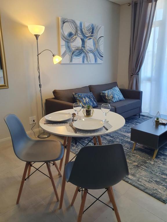 a living room with a table and chairs and a couch at The Paramount and The Supreme at Bellamare in Summerstrand