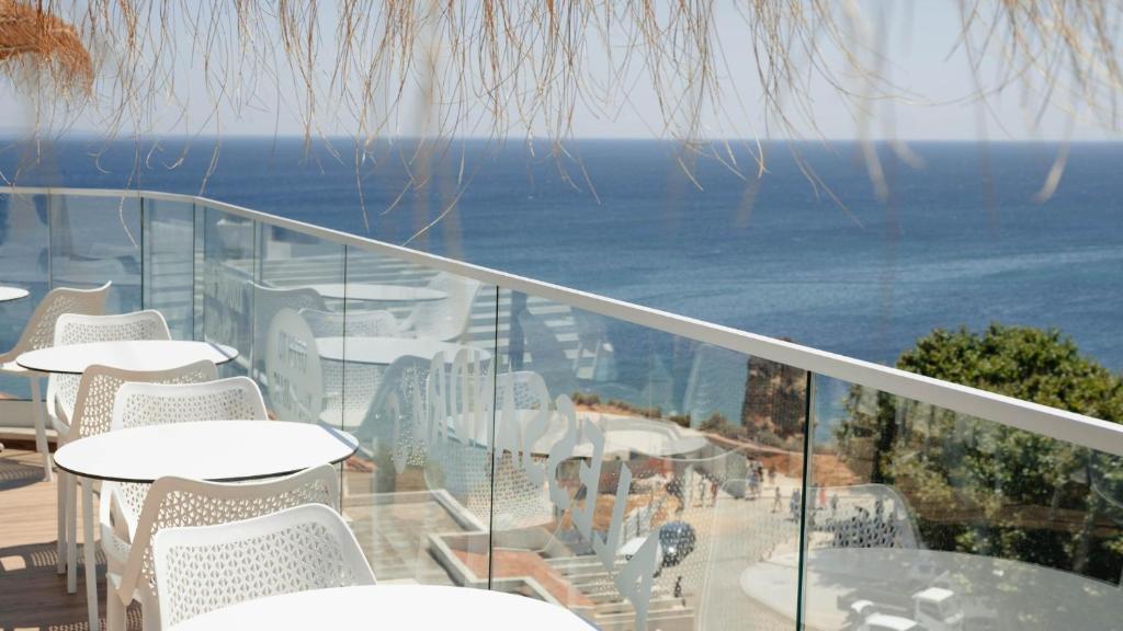 a balcony with tables and chairs and the ocean at Carvi Beach Hotel in Lagos