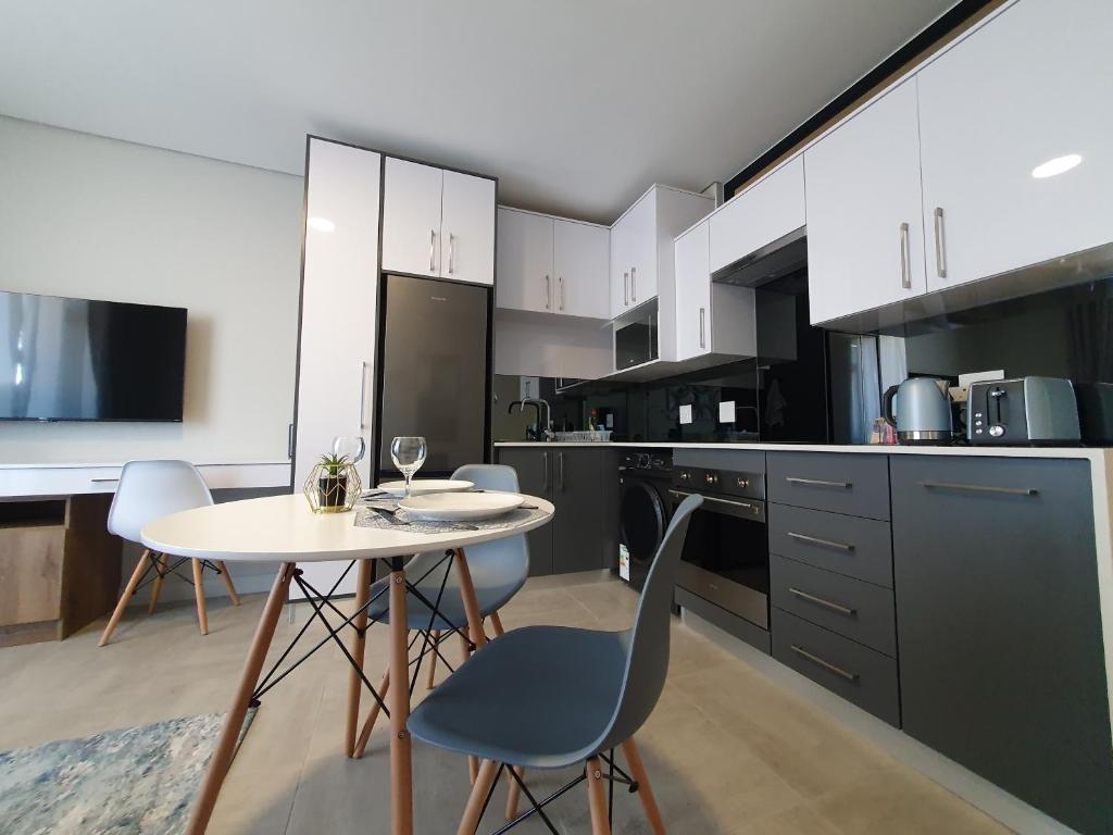 a kitchen with a white table and chairs and a table and a table and chairs at The Paramount and The Supreme at Bellamare in Summerstrand