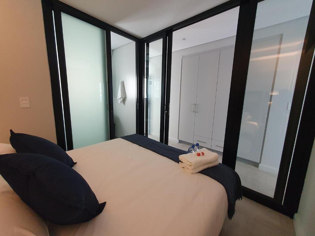 a bedroom with a large bed with black pillows at The Paramount and The Supreme at Bellamare in Summerstrand