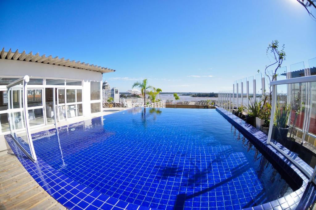 a swimming pool with blue tiles on the side of a building at Hotel Continental Porto Alegre e Centro de Eventos in Porto Alegre