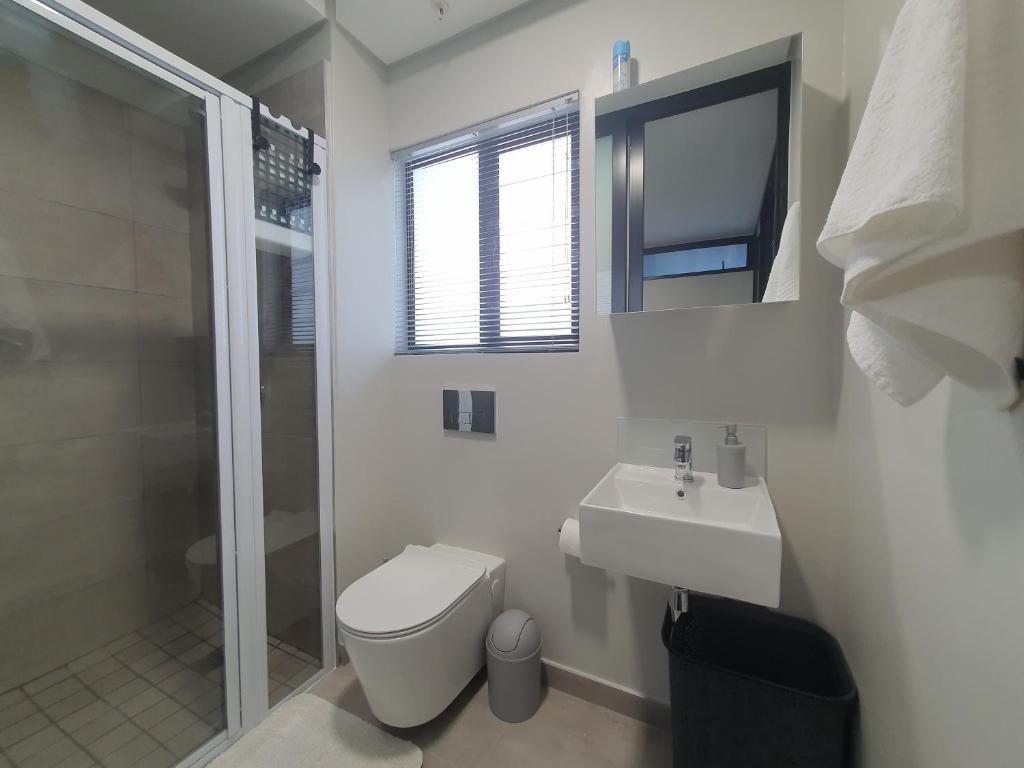 a bathroom with a toilet and a sink and a shower at The Paramount and The Supreme at Bellamare in Summerstrand