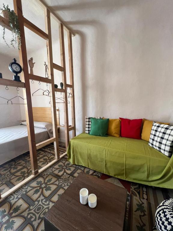 a living room with a green couch and a table at Trulli & Case Fichi 3 in Bari