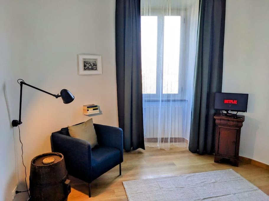 a living room with a blue chair and a television at Alcova delle Arvolte in Narni