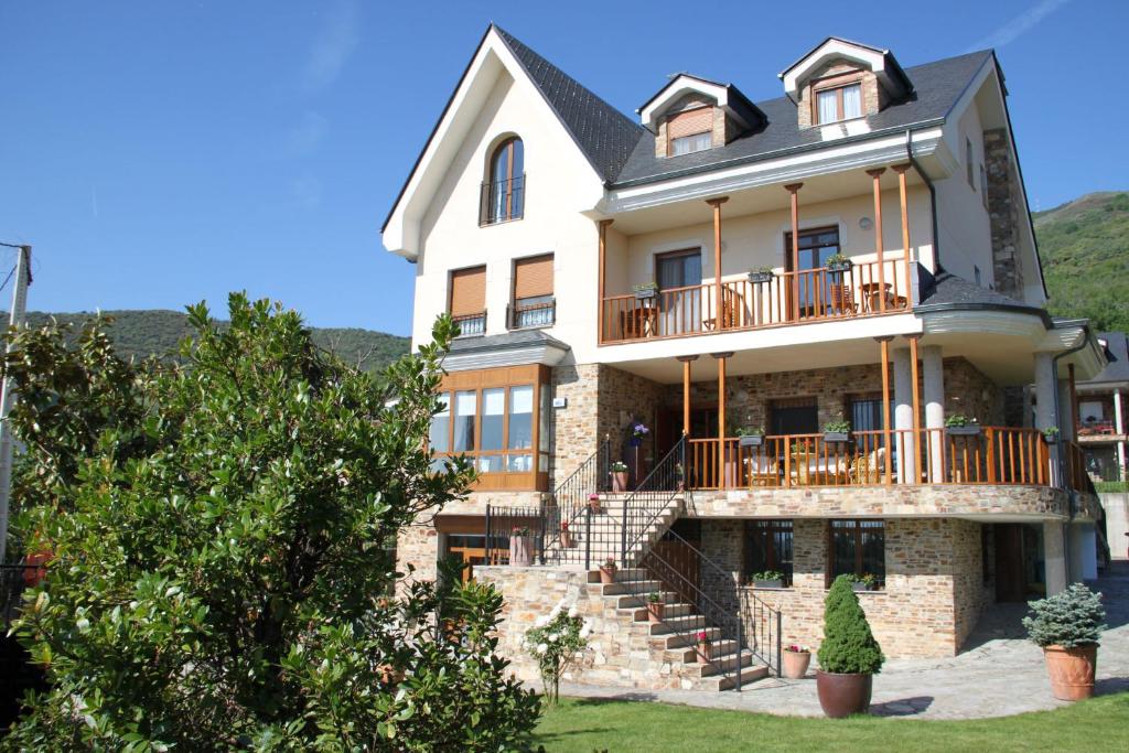 ein großes weißes Haus mit einem Balkon und einer Treppe in der Unterkunft Villa Mencia in Corullón