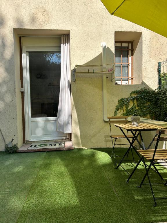 d'une terrasse avec une table et une fenêtre. dans l'établissement Studio Riviera proche de Cannes, au Cannet