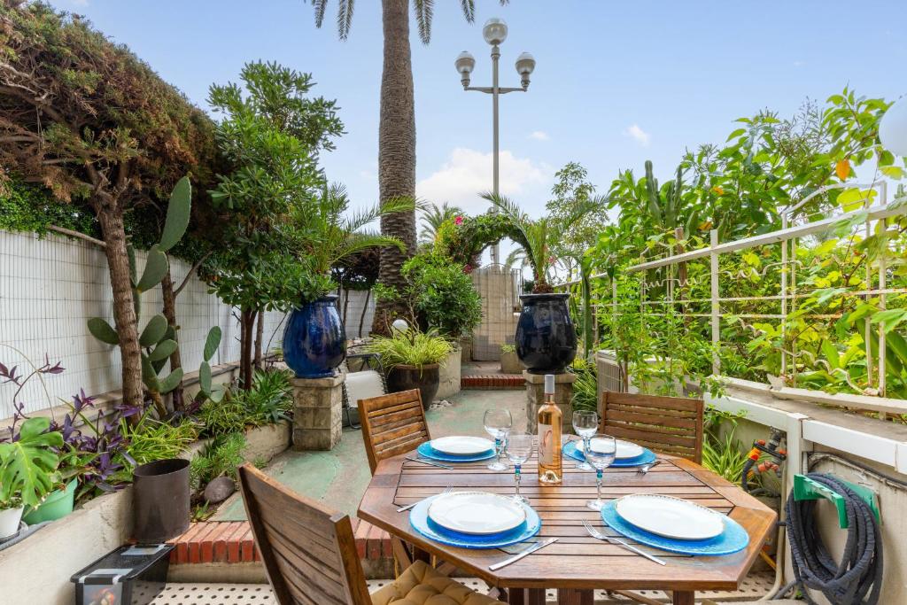 une table et des chaises en bois sur une terrasse dans l'établissement Happyfew La Promenade 53, à Nice