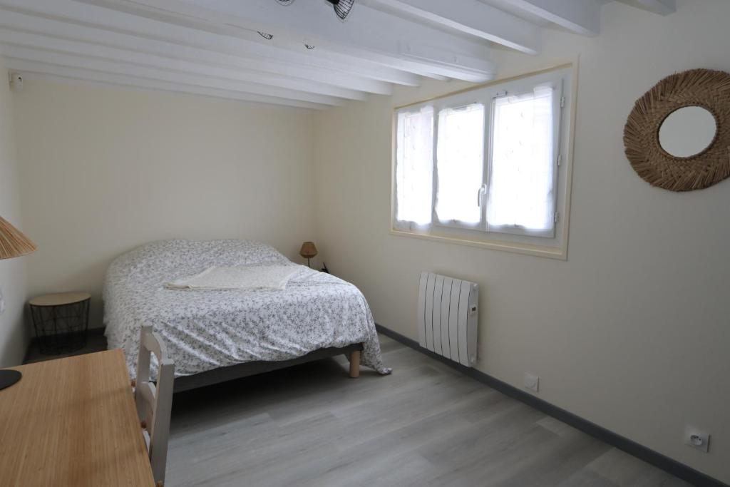 a bedroom with a bed and a window and a table at Maison individuelle aux portes de la Sologne in La Ferté-Saint-Aubin