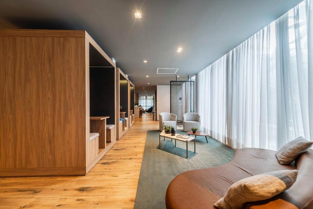 a living room with a couch and a large window at NK | Vila Mariana | Localização Perfeita in São Paulo