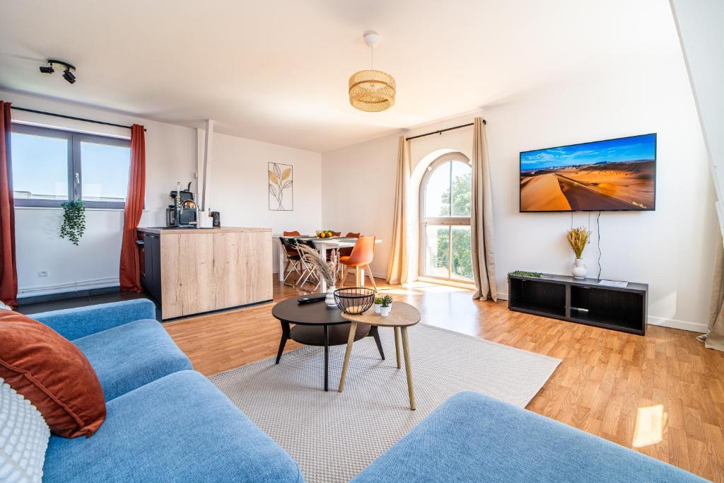 a living room with a blue couch and a table at Le Saint-Jean - Hypercentre - Parking privé - 1 à 6 personnes - Wifi in Roubaix
