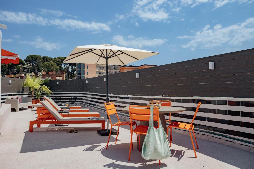 a patio with a table and chairs and an umbrella at Hotel Robson - Smart Hotel in Lloret de Mar