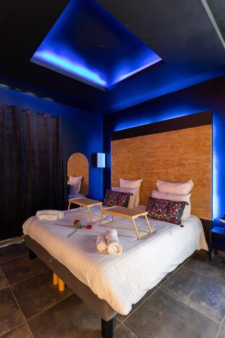 une chambre avec un grand lit avec un plafond bleu dans l'établissement Le Pont des Amoureux Jacuzzi Wifi, à Cournon-dʼAuvergne