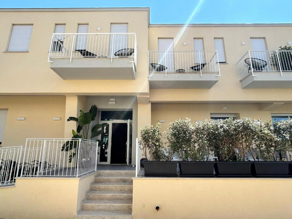 a building with stairs and plants on the balconies at Hotel Perla in Castiglione della Pescaia
