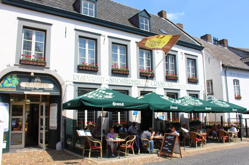 eine Gruppe von Personen, die außerhalb eines Gebäudes an Tischen sitzen in der Unterkunft Hotel Crasborn Thorn in Thorn