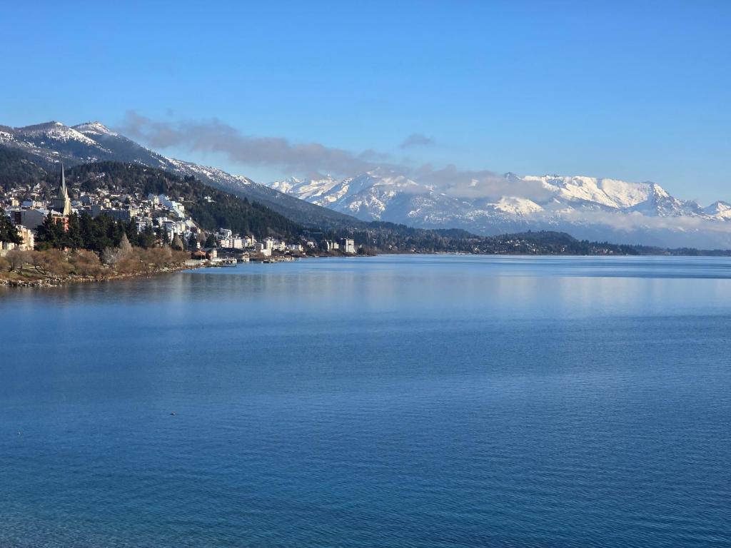 a large body of water with snow covered mountains at Paraiso del lago in San Carlos de Bariloche