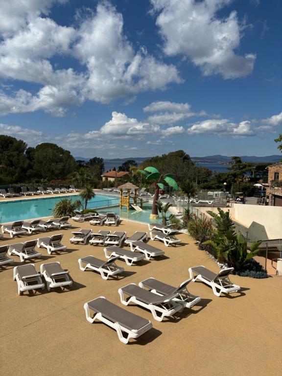 un groupe de chaises longues et une piscine dans l'établissement Bungalow de Luxe, New, Top-of-the-range amenities, Air conditioning, Jacuzzi and Sea view, à Saint-Raphaël
