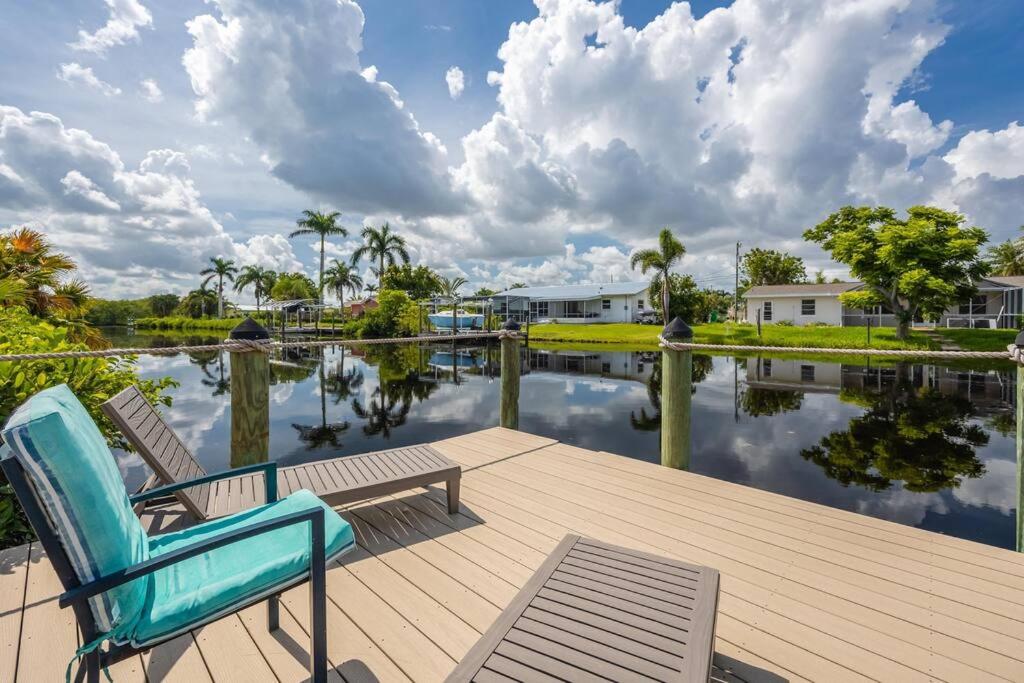 a couple of chairs sitting on a dock next to a body of water at Welcome To Sanctuary & Flair - Casa de Photograph in North Fort Myers