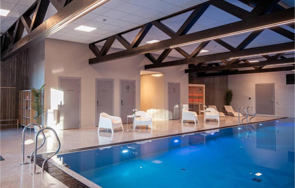 a swimming pool with chairs and a table at Modern apartment in Åros with swimming pool!-Moderne leilighet på Åros med svømmebasseng! in Søgne