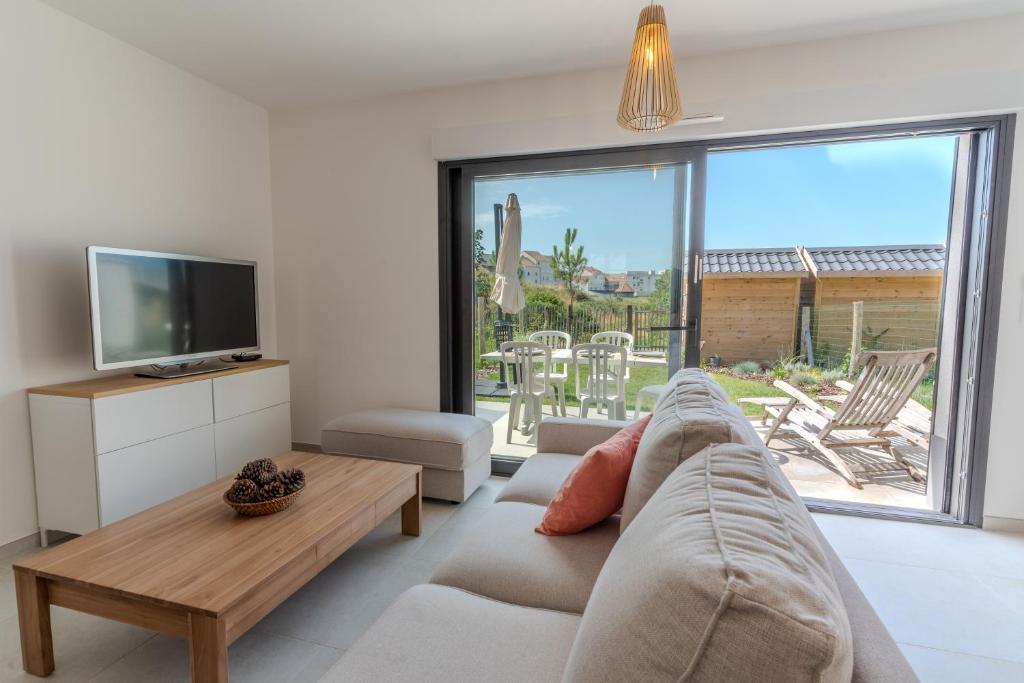 un soggiorno con un divano e una grande finestra di Superbe maison neuve proche centre-ville et plage pour 4 personnes a Neufchâtel-Hardelot