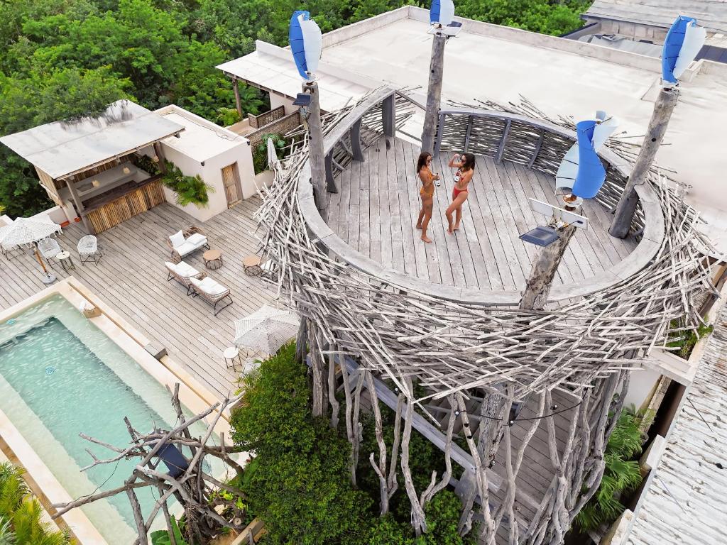 due donne che camminano su un ponte di corda accanto a una piscina di Kuunaa Tulum I Beer Sanctuary & Spa a Tulum