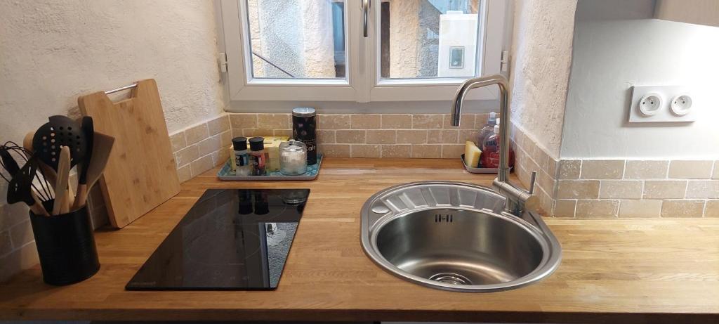 a kitchen with a sink and a counter top at Studio Isaline RDC in Saint-Ambroix