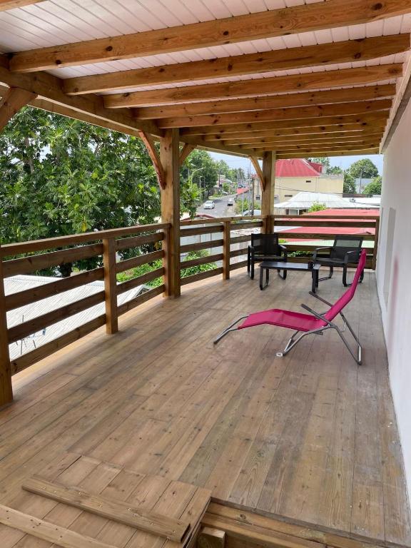 a wooden deck with a picnic table and a bench at Bethanie in Le Gosier