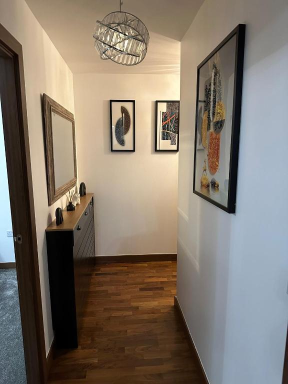 un pasillo con espejo y cuadros en la pared en JEMNACYA Apartments, en Kent