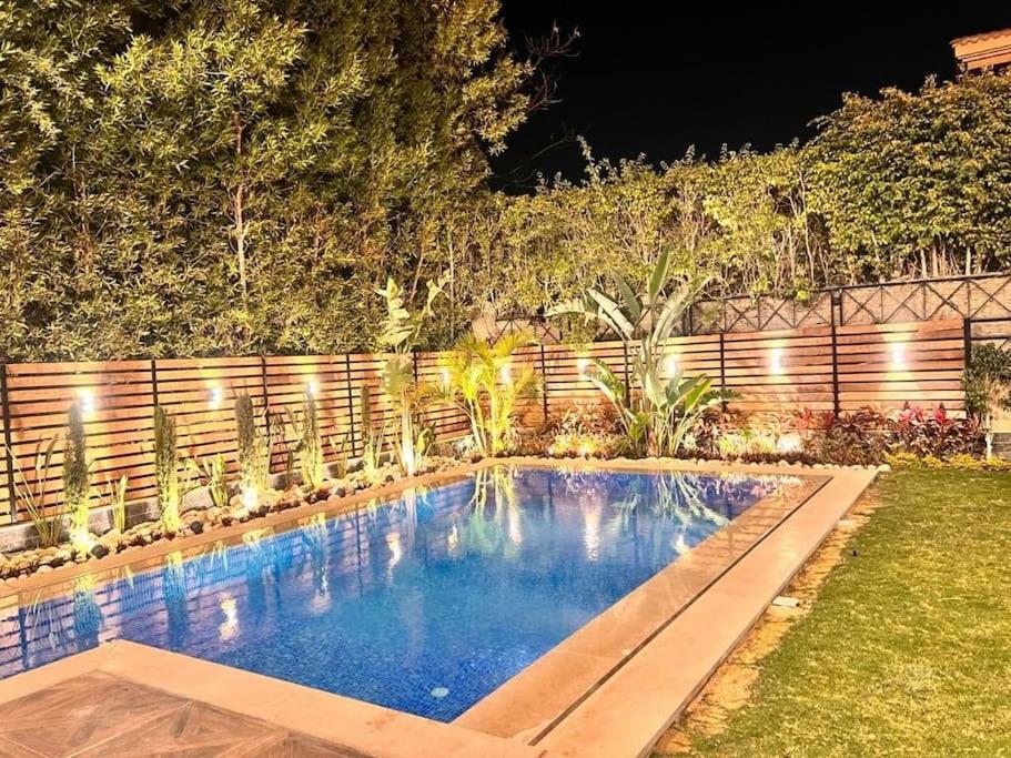 a swimming pool in a backyard at night at villa Yasser Ezzat in Cairo