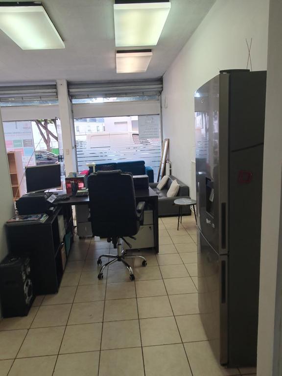 un bureau avec un bureau et un réfrigérateur dans l'établissement Confort appartement, à Chaville