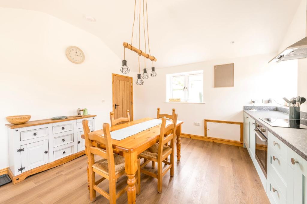 a kitchen with a table and chairs in a room at Well-located countryside cottage in Nailsea