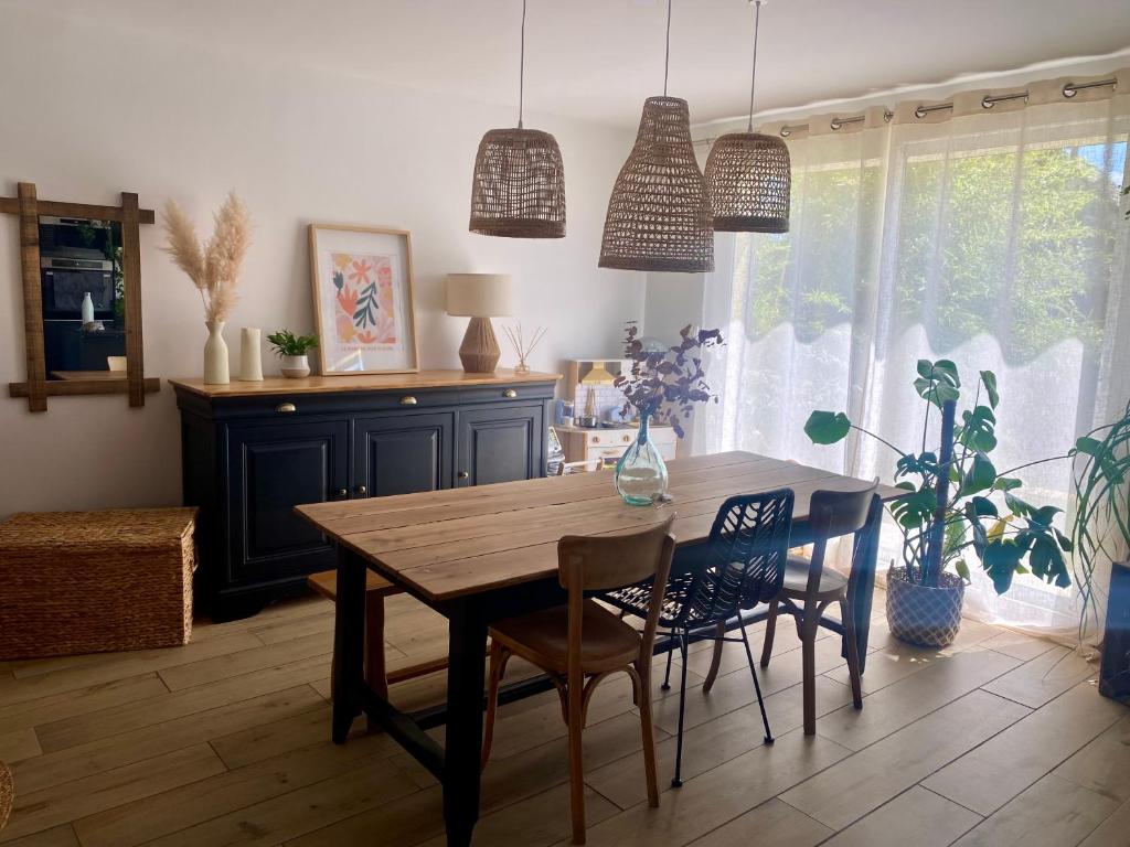 une salle à manger avec une table et des chaises en bois dans l'établissement Maison 90m2 15min du circuit des 24h du Mans 7 couchages, au Mans