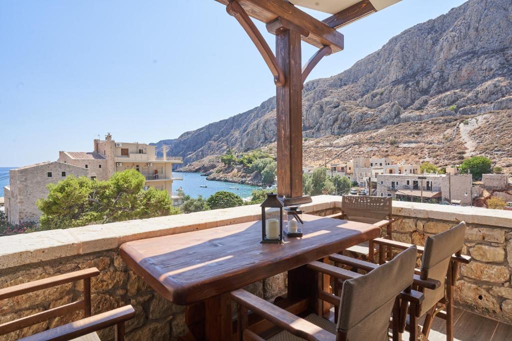 a wooden table and chairs on a balcony with a view at Porto Santo in Gerolimenas