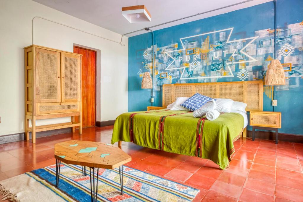 ein Schlafzimmer mit einem Bett und einem Wandgemälde in der Unterkunft Socialtel Atitlan in Panajachel