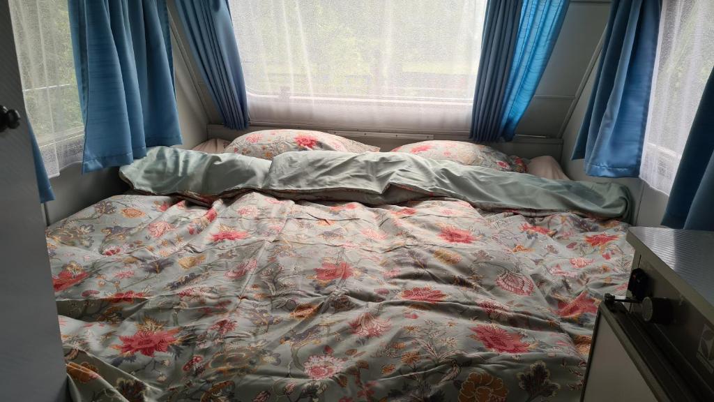 un letto non rifatto in una stanza con finestra di B&B De Vretberg a Enschede