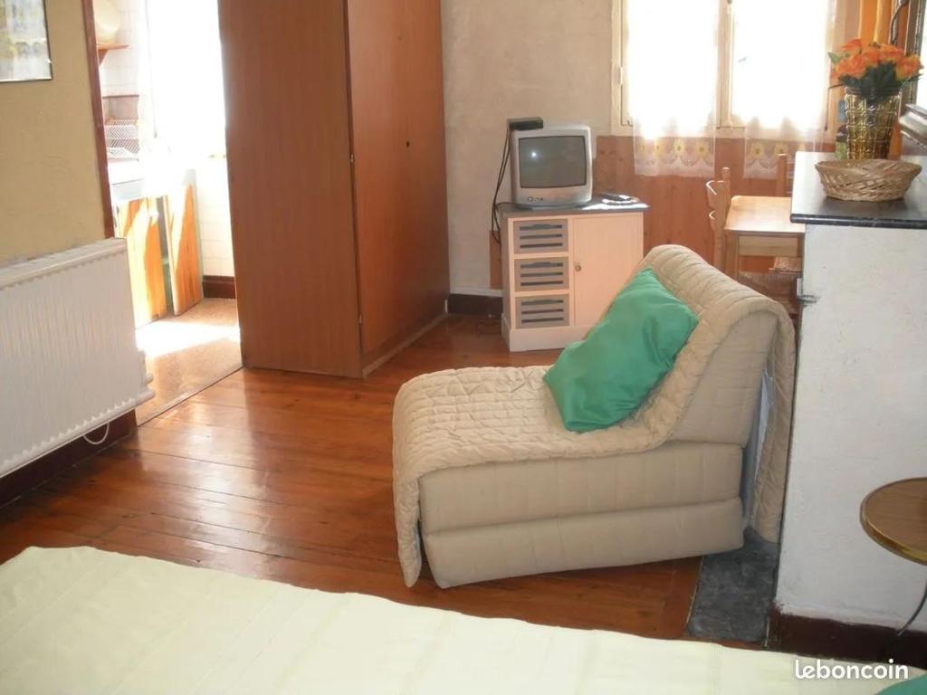 un salon avec un canapé et une télévision dans l'établissement Gîtes autonomes chez l'habitant 2, à Bagnères-de-Bigorre