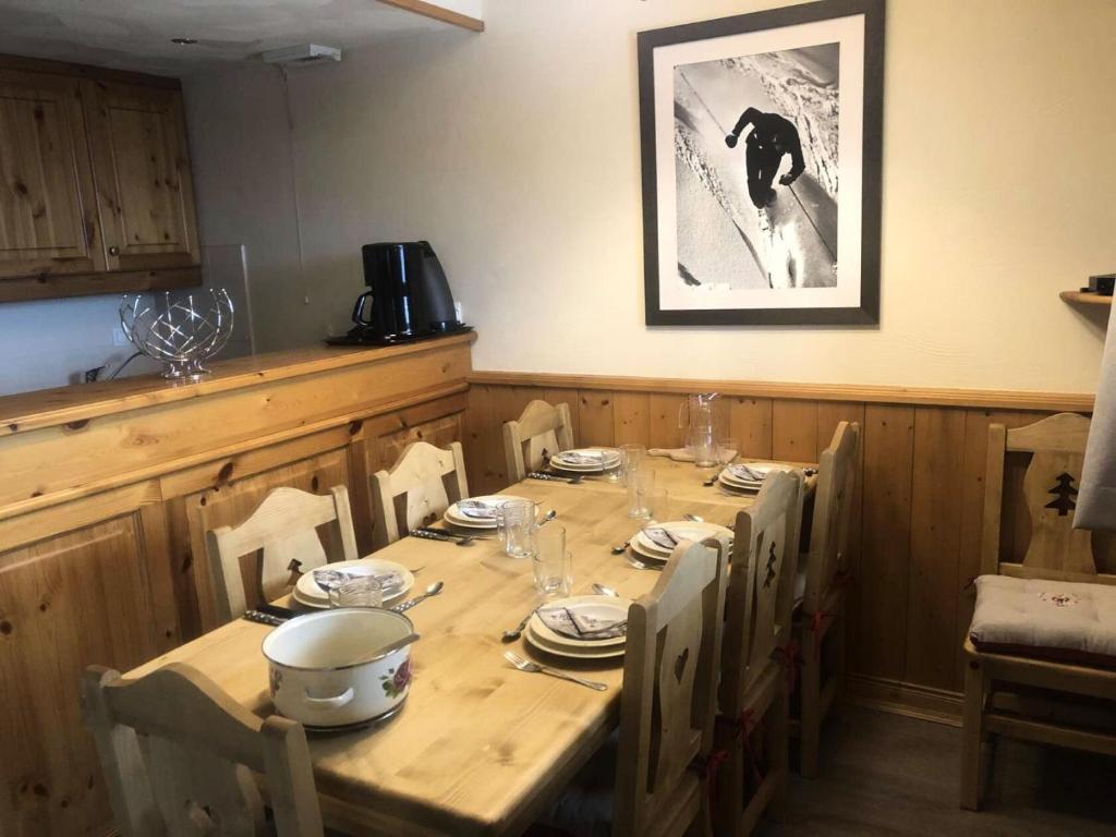 - une table en bois avec des assiettes et de la vaisselle dans l'établissement Résidence Valeriane - La Valériane 18 - Appartement offrant une vue magnifique sur la vallée MAE-5364, à Valmorel