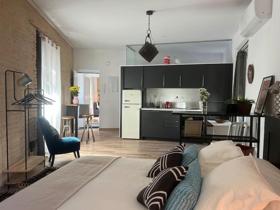Hotel Acogedor estudio en Alameda Centro, a bedroom with a large bed and a kitchen at Acogedor estudio en Alameda Centro in Seville