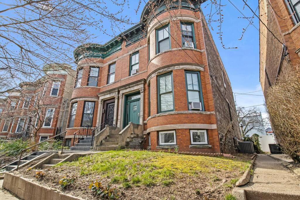 un gran edificio de ladrillo con una puerta verde en Beautiful Green Door Brownstone, en Jersey City
