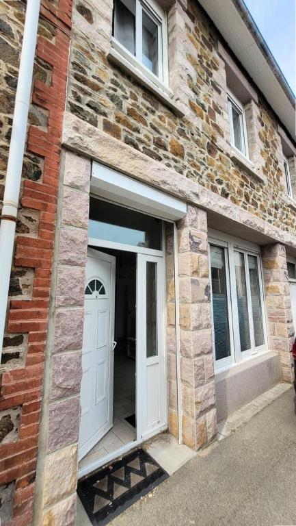 - un bâtiment en briques avec une porte et des fenêtres blanches dans l'établissement Résidence 590-pleneuf Val Andre - Vacances les pieds dans l'eau, dans le coeur de la station du VAL ANDRE MAE-5191, à Pléneuf-Val-André